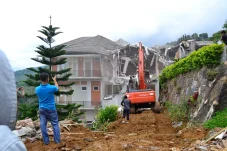 Alat berat membongkar salah satu bangunan villa yang tidak berizin di Kawasan Puncak, Kabupaten Bogor